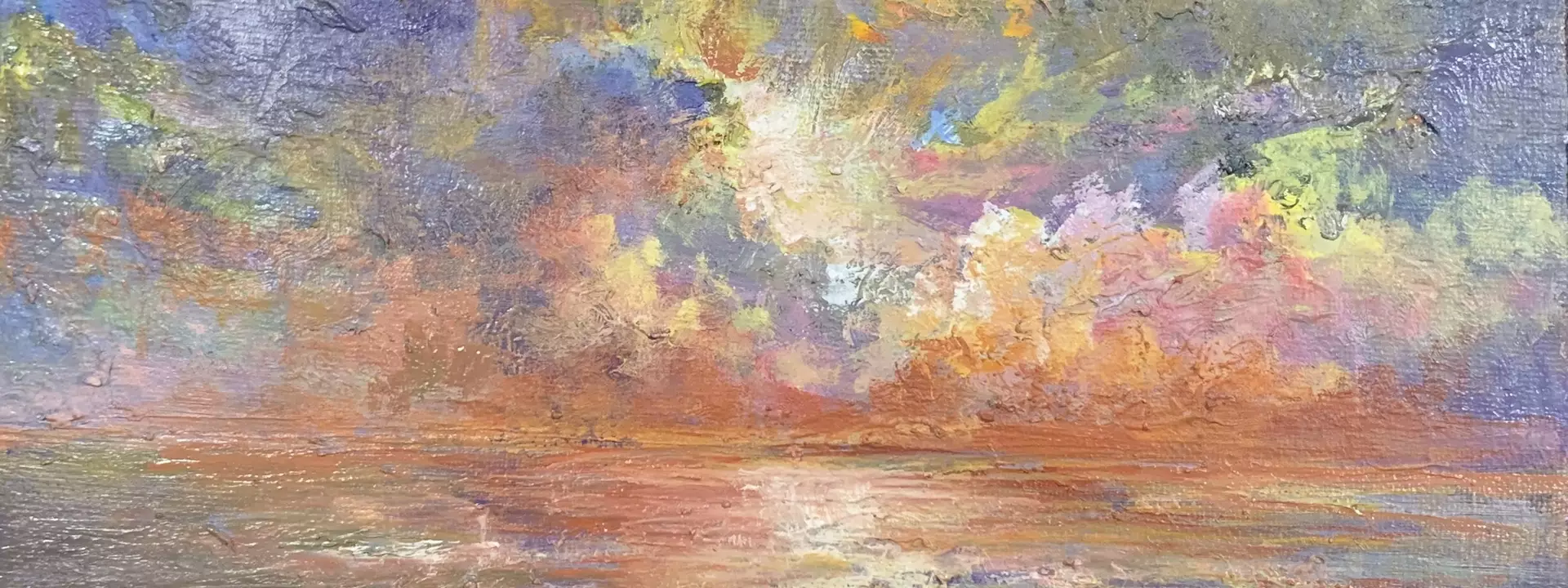 A blazing sunset over a beach in reds, yellow, purple and blue. Dramatic seascape.