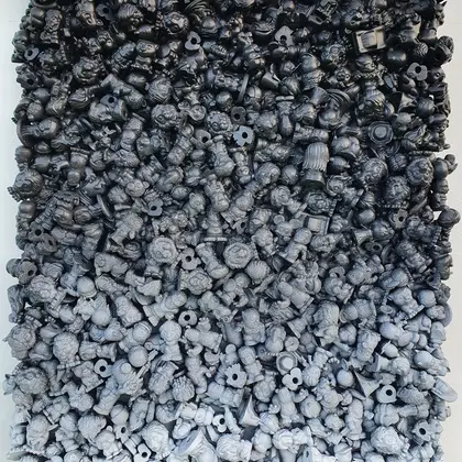 wall sculpture of rubber toys spray painted in black and white paint