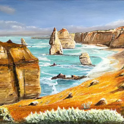 Bright rock columns against a blue sea with waves and rock cliffs.