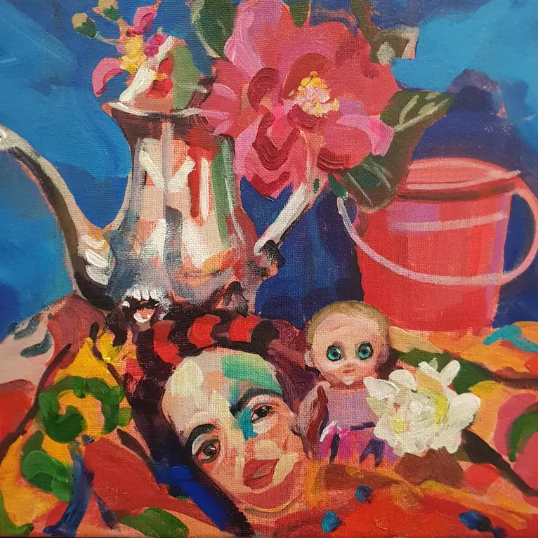 An exotic scarf printed with a Gustave Klimt painting is reflected in a silver teapot. A kewpie doll and some bright flowers…