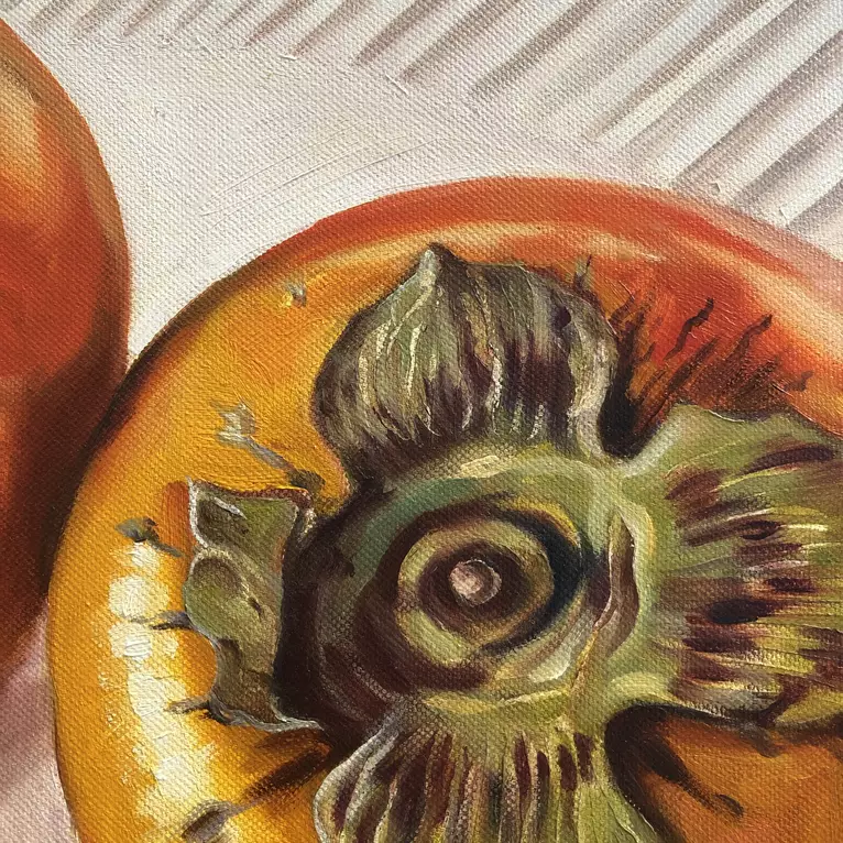 Two orange Persimmon fruits reflected on knife blade — shown hanging