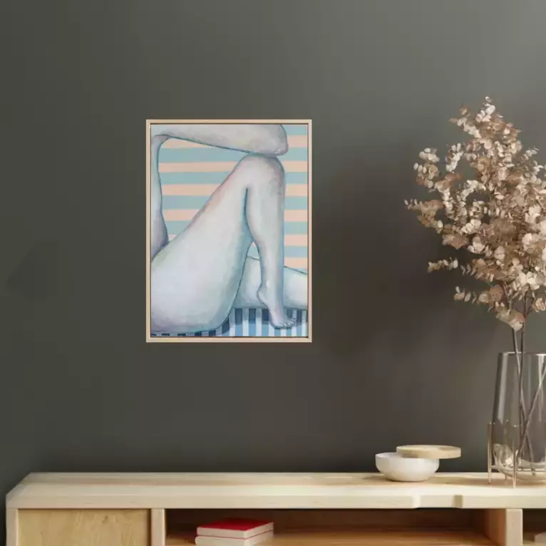 A framed painting of nude legs crossed, one over the other, with soft skin tones. Blue-grey and wh… — shown in a room setting