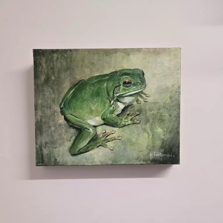 A detailed realism painting of an old green tree frog with golden eyes, pale underbelly, and visible webbing… — shown hanging