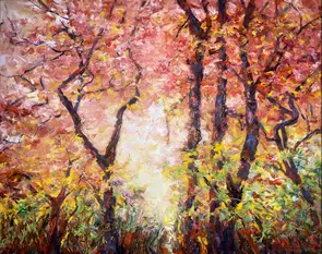 Red pink and yellow autumn trees and foliage in forest with pale blue sky background.