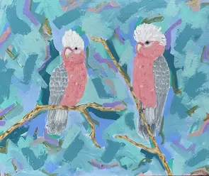 Two galahs sitting on a branch with a early morning misty sunrise backdrop