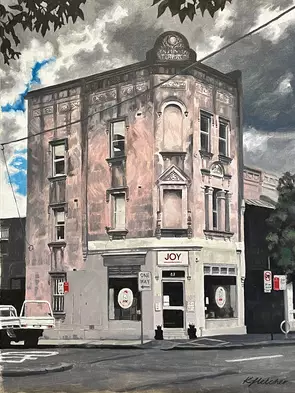 Old pink building, sun breaking through dark clouds, Joy written on sign on building.