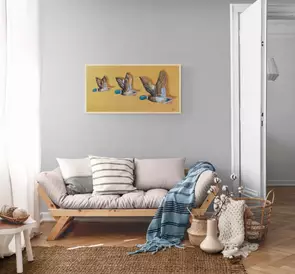 A set of 3 still life ceramic flying ducks shown on a golden wall.
