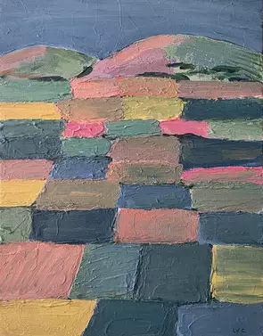 Coloured fields in pastel tones with mountains in the background.