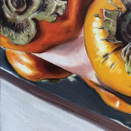 Two orange Persimmon fruits reflected on knife blade — detail