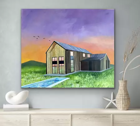 A barn style building set on a field with a pool against a vibrant sky of purple and orange
