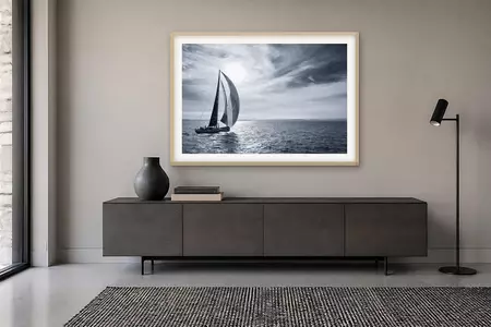 A racing yacht sails across glittering water beneath a dramatic streaked sky with the sun breaking through, Sydney to Hobart…