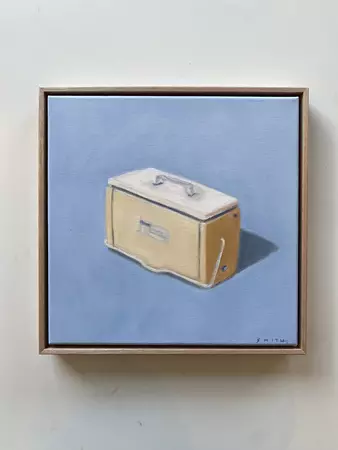 a yellow cooler with shadow on a blue background — shown hanging